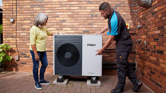 A British Gas engineer explaining a heat pump to a customer