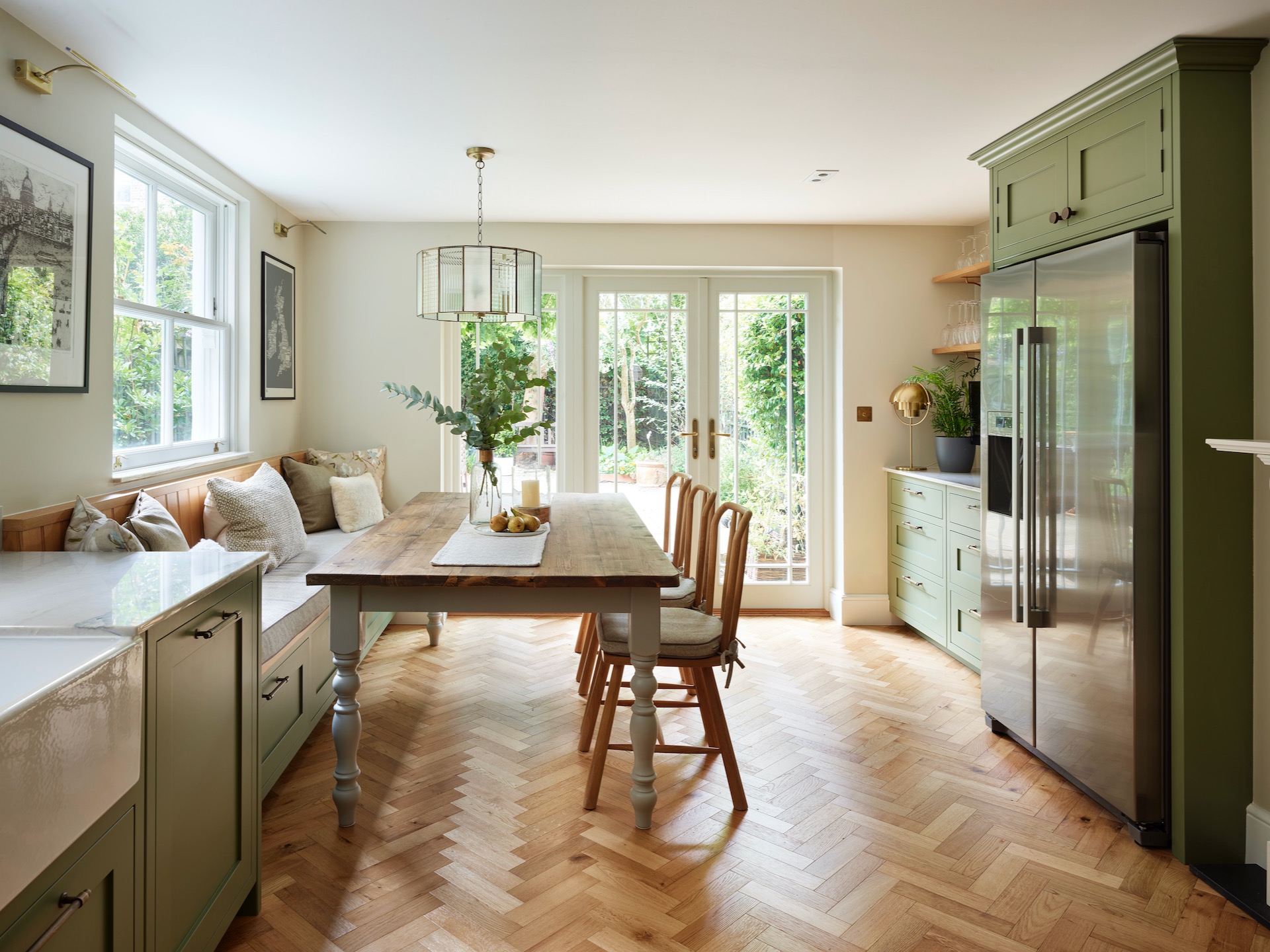 Sage green kitchen with French doors onto the garden