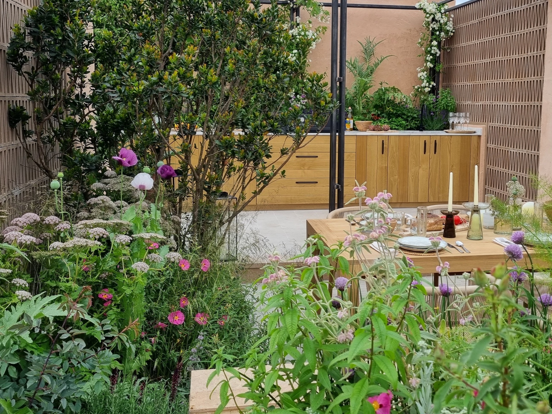 Garden kitchen and dining area surrounded by planting