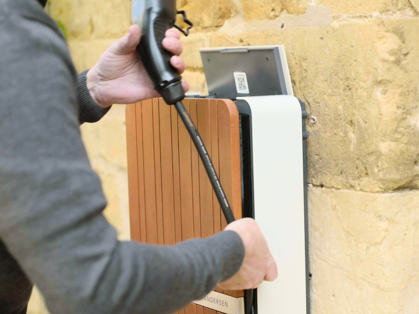 Person holding tethered EV charging socket