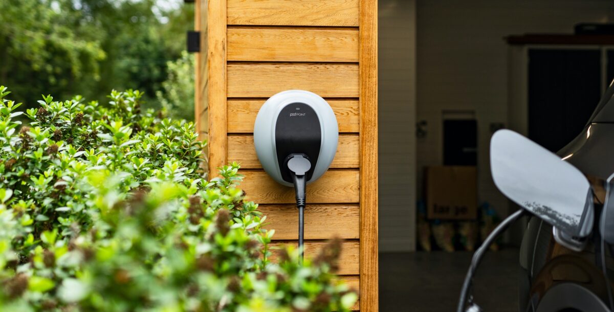 Pod Point EV car charger on timber clad garage wall