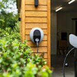 Pod Point EV car charger on timber clad garage wall