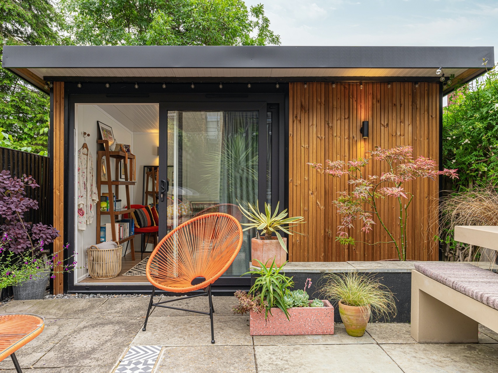Garden room with timber cladding and range garden chair