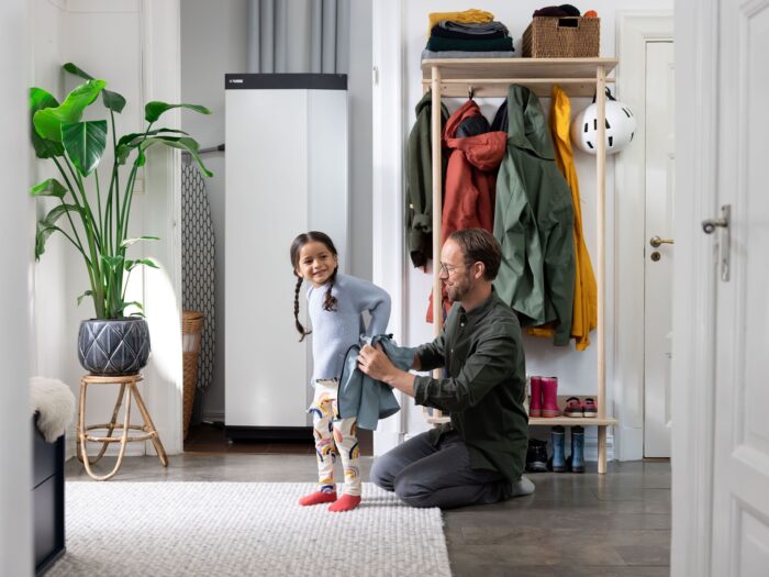 Family in room that has the interior unit from a ground source heat pump