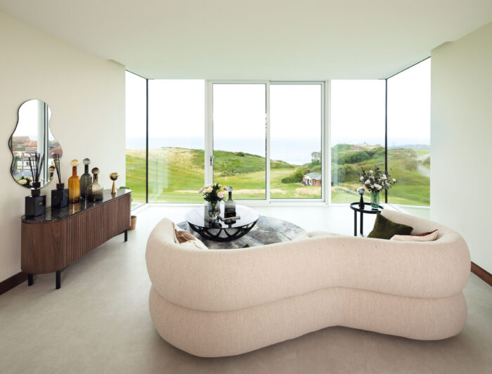 Curved living room furniture includes a Sense sofa and a Remi sideboard from Heal’s
