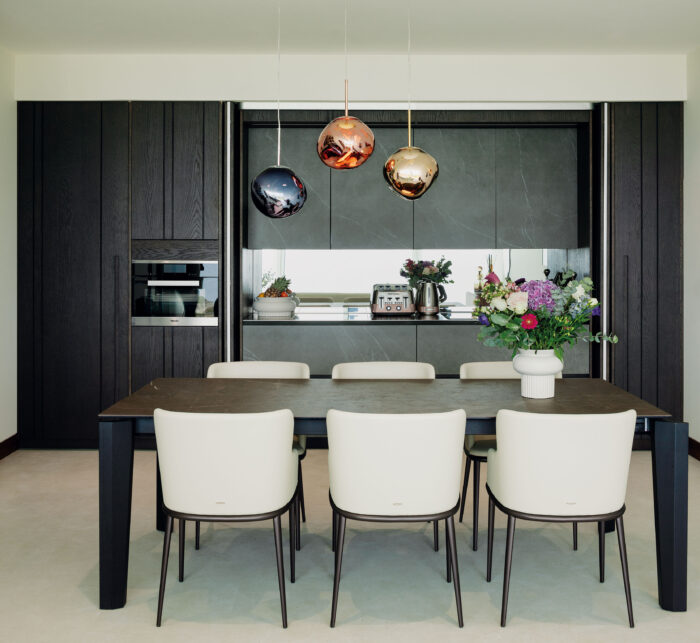 A second- hand kitchen from The Used Kitchen Company features steel worksurfaces, sintered stone-faced cabinets and built-in appliances