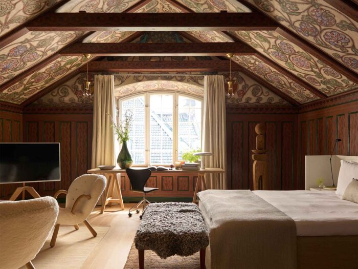 The cosy bedroom are wood-panelled with beams and strong prints