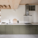 Kitchen with L-shape layout and sage green cabinet fronts