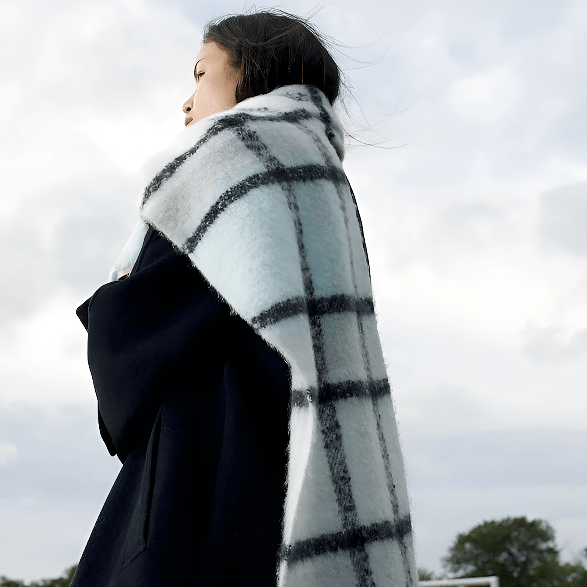 A woman wearing a plaid throw