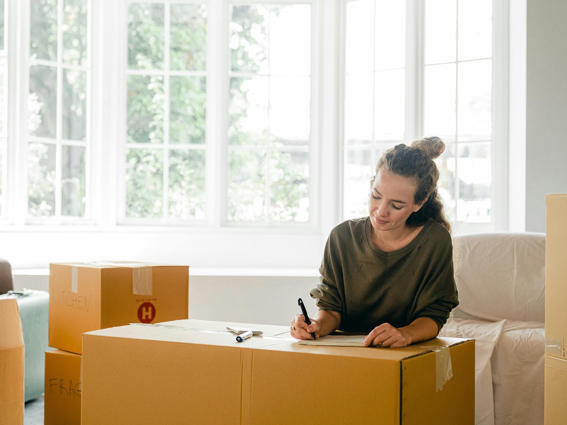 A woman writing on a removal box