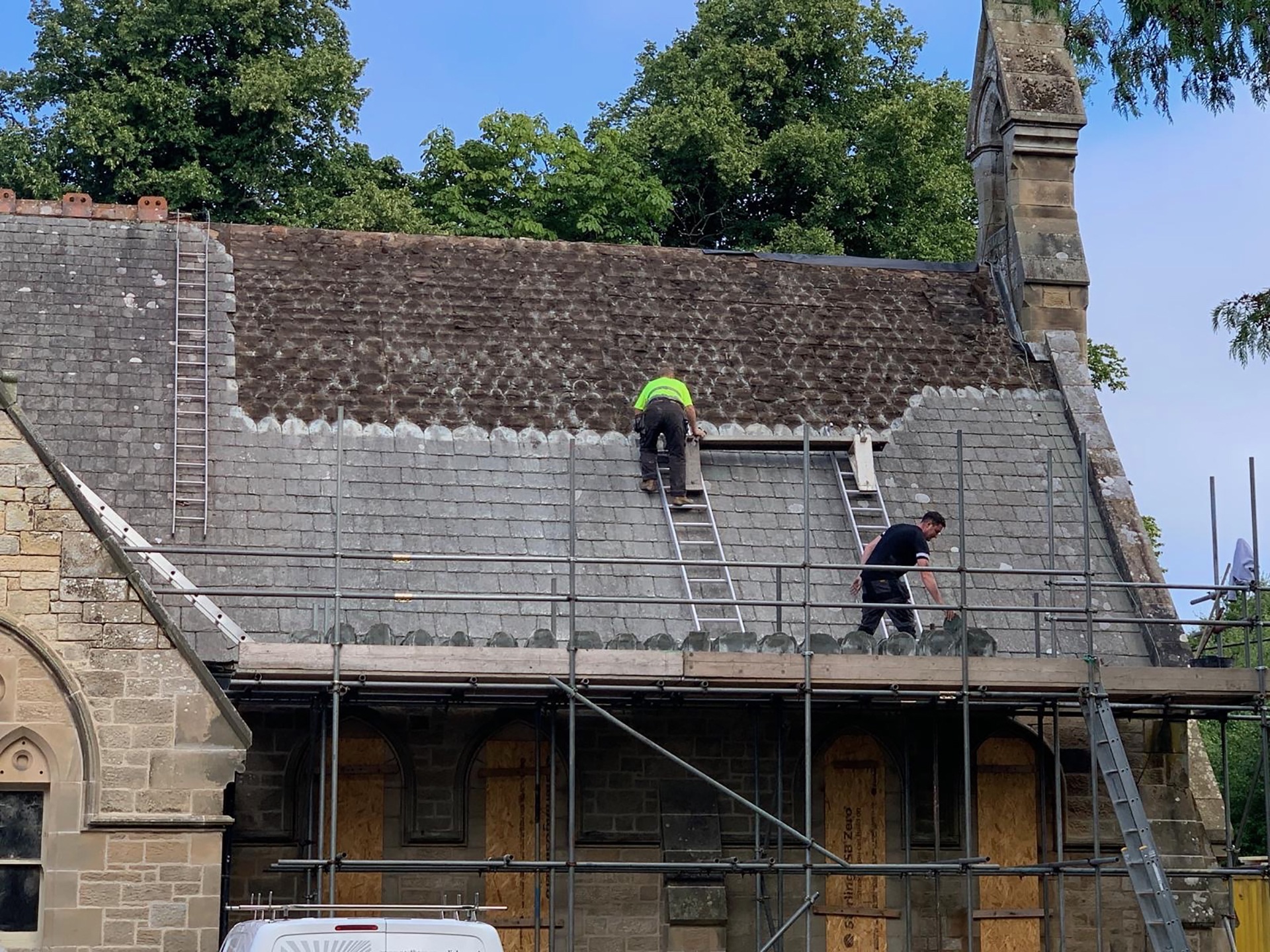 Men removing tiles from the roof of Warksburn Old Church