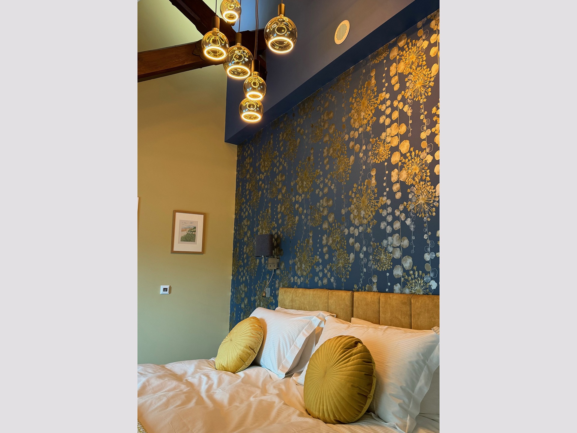 A bedroom with feature wall and designer light fitting