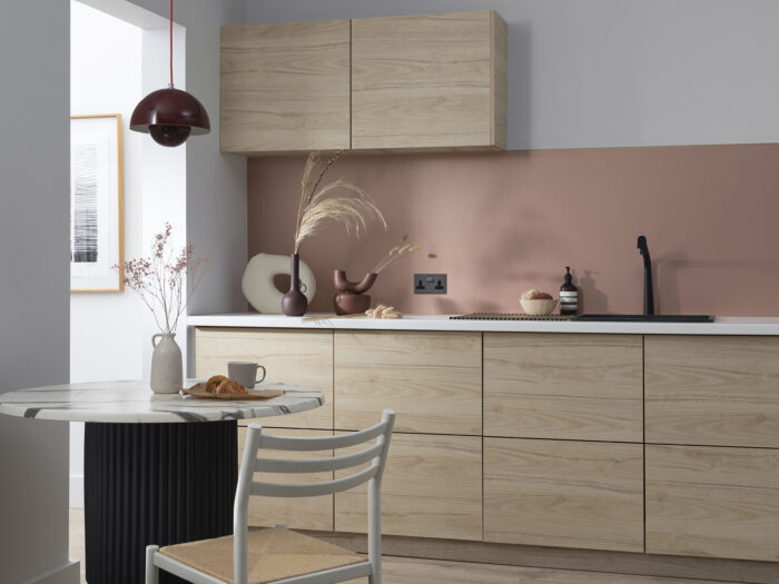 A kitchen with a pink splashback
