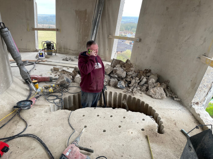 A workman cutting concrete from the tank at Tonwell Tower
