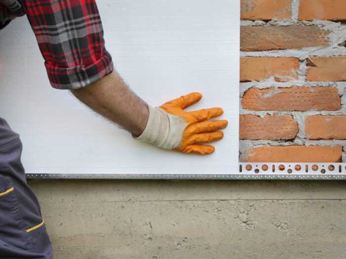 A workman installing external wall insulation