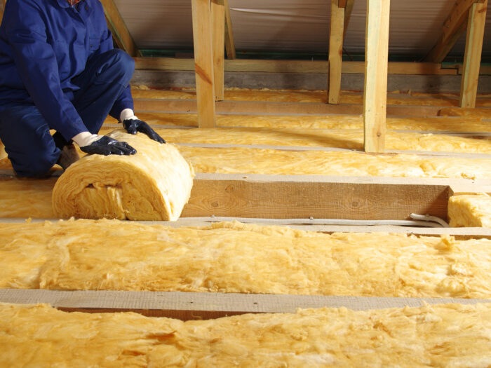Someone installing loft insulation