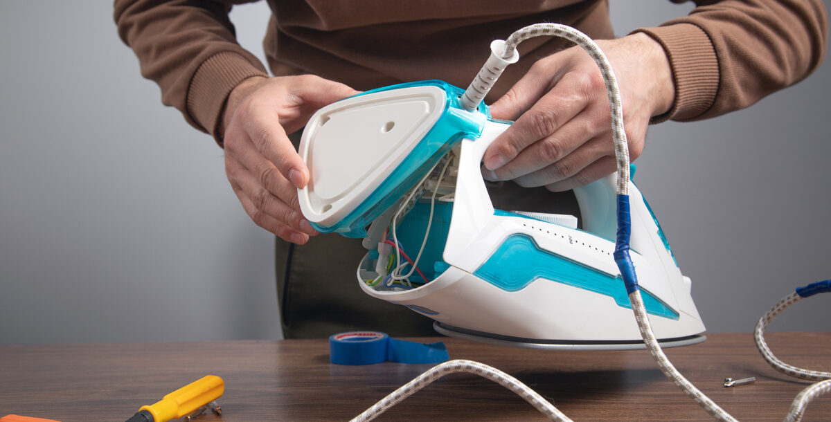 Caucasian man repairing broken iron. Iron repair