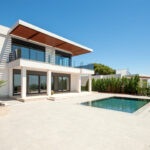 The modern facade of a luxury villa with a large swimming pool. Luxury MODERN property.