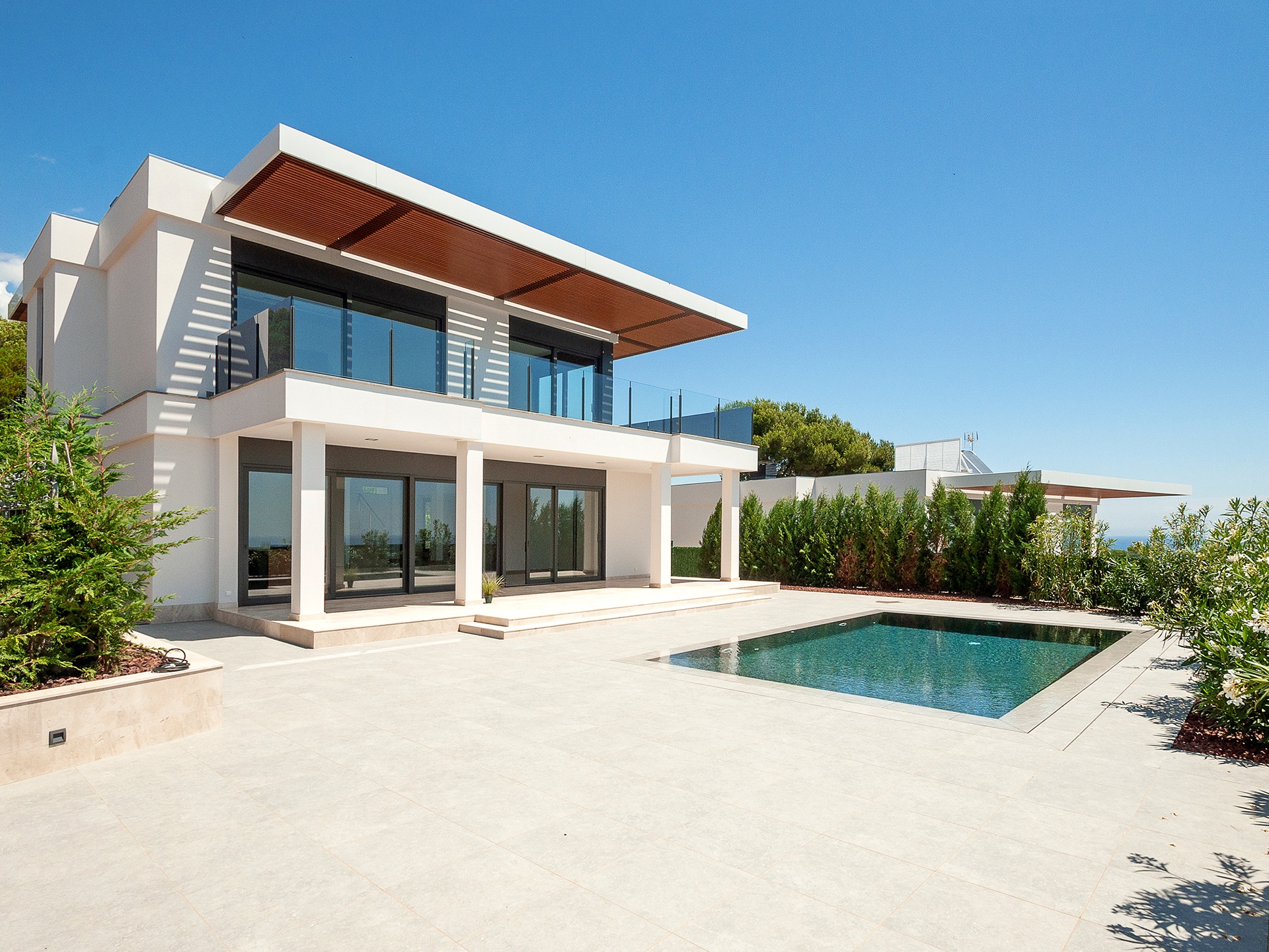 The modern facade of a luxury villa with a large swimming pool. Luxury MODERN property.