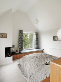 The master bedroom in the new extension has a picture window and windowseat offering views of the garden. Photo: Leighton James