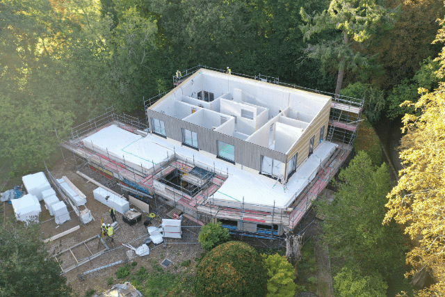 Baufritz house being erected on top of the Glatthaar foundations, showing project progressing to above ground phase.