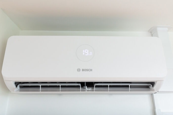 A close-up of a white air conditioning unit on the wall, it says 19 on the display