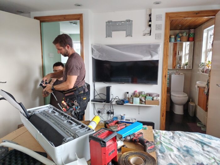 Fitters at work, there's a mess of tools on the bed