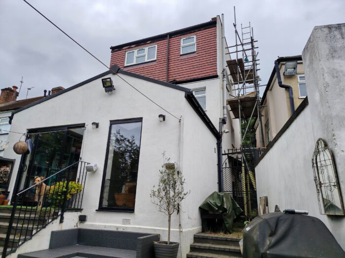 The rear of a house with an extension, scaffolding is visible at the side